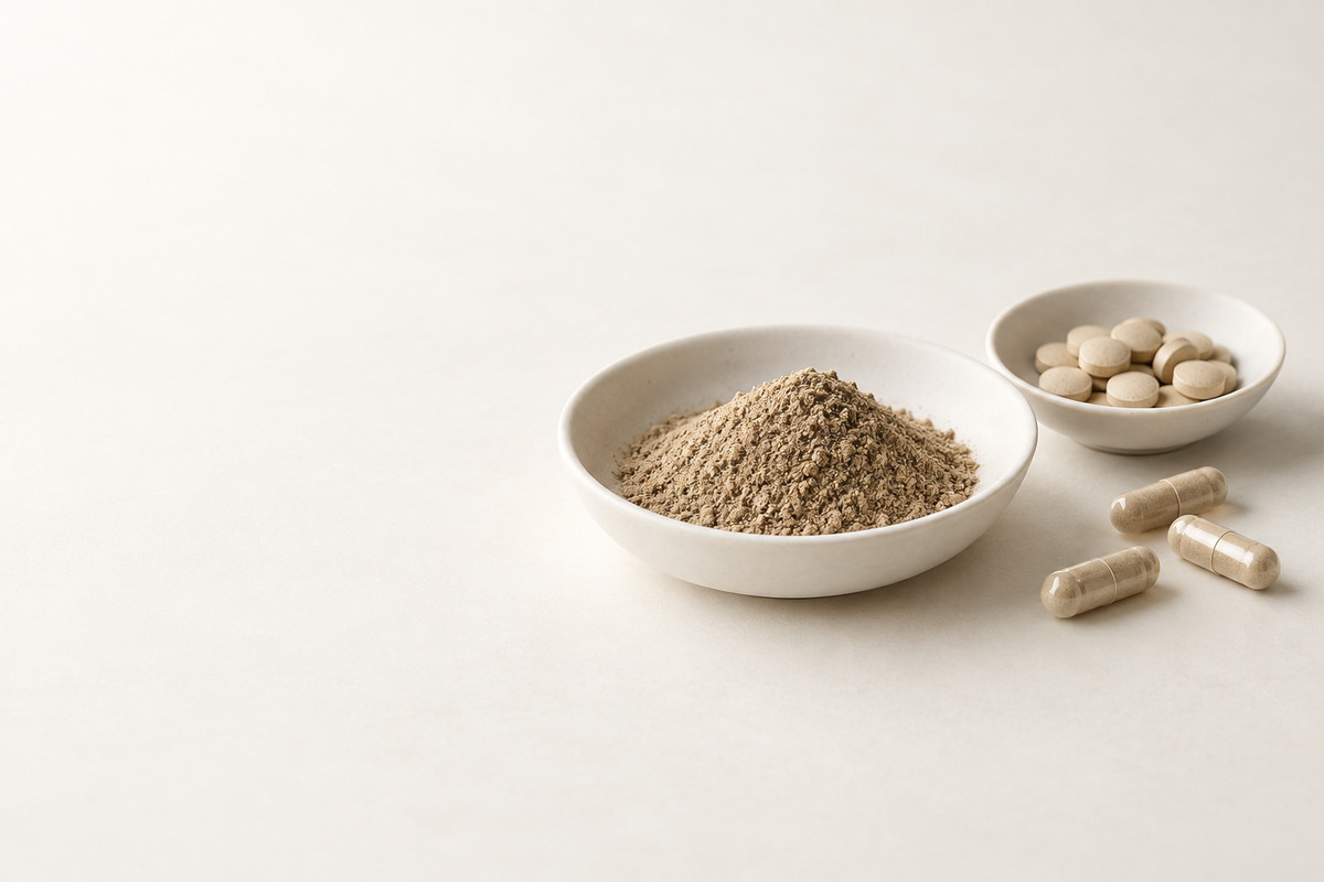 Illustratives Stillleben mit Granulat, Tabletten und Kapseln in hellen Keramikschalen